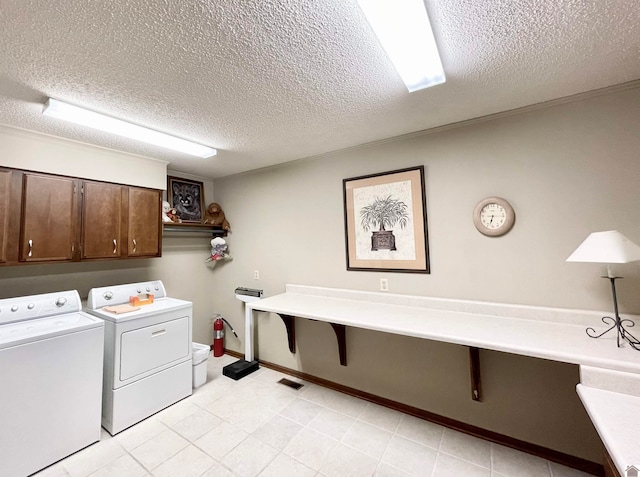 laundry room with independent washer and dryer, light tile flooring, and a textured ceiling