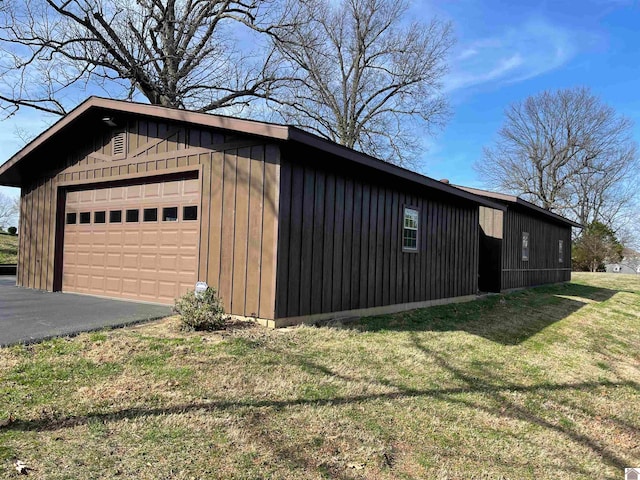 view of side of home featuring a garage and a yard