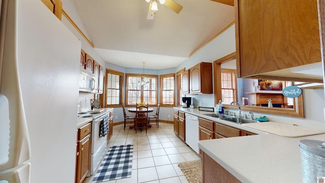 kitchen featuring light tile floors, sink, white appliances, ceiling fan with notable chandelier, and hanging light fixtures