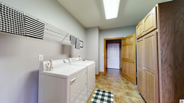 washroom with independent washer and dryer, light tile floors, and cabinets