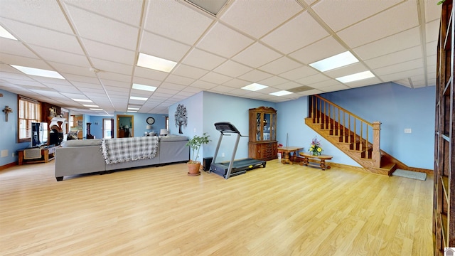 workout room with light hardwood / wood-style floors and a drop ceiling