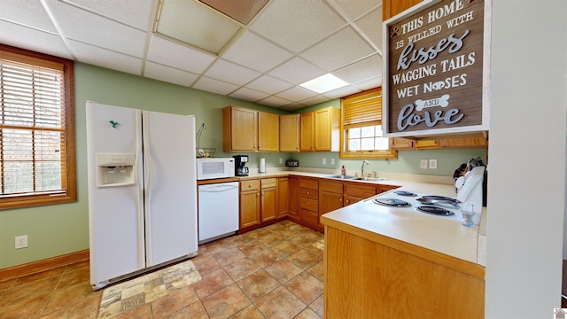 kitchen with white appliances, sink, a drop ceiling, and light tile flooring