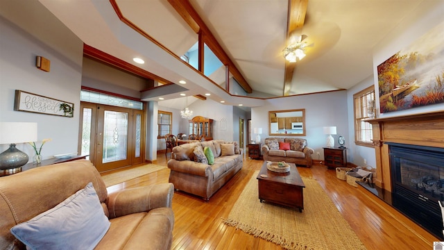 living room featuring ceiling fan, lofted ceiling with beams, and light hardwood / wood-style flooring