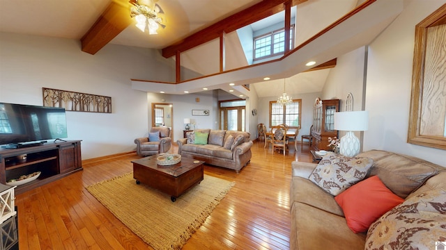 living room with light hardwood / wood-style flooring, a notable chandelier, beam ceiling, and high vaulted ceiling