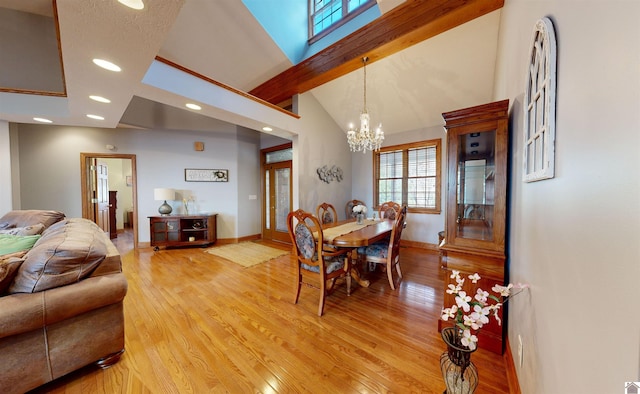 dining area featuring a notable chandelier, high vaulted ceiling, light hardwood / wood-style floors, and beamed ceiling