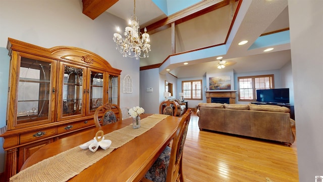 dining room featuring a chandelier, light wood-type flooring, and beamed ceiling