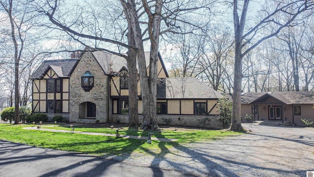 english style home featuring a front lawn