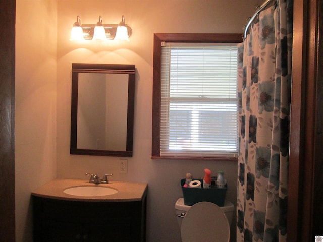 bathroom with toilet, a healthy amount of sunlight, and vanity