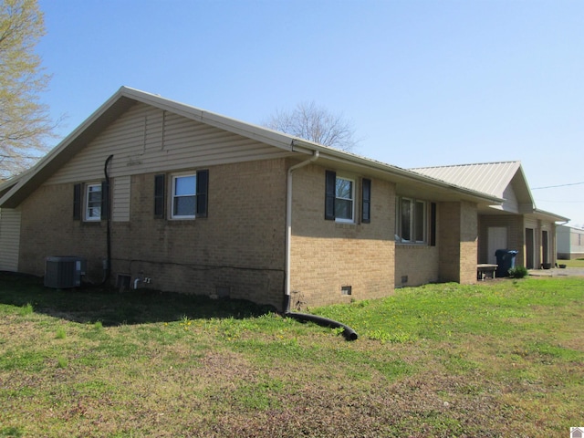 view of side of home featuring central AC unit and a lawn