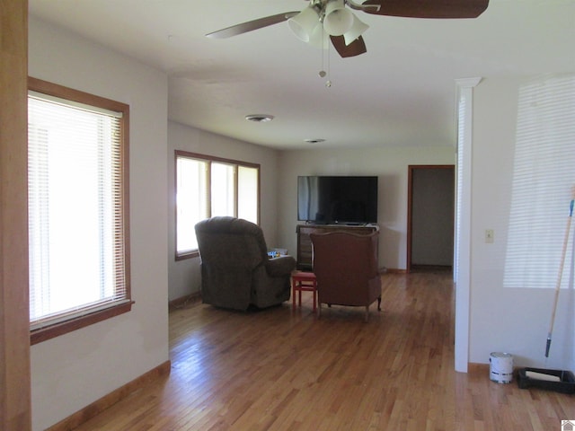 living room with ceiling fan, plenty of natural light, and dark hardwood / wood-style floors