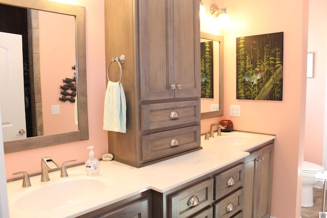 bathroom with toilet, tile floors, and dual vanity