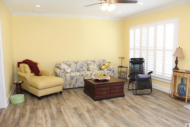 living room with ceiling fan, crown molding, and light wood-type flooring