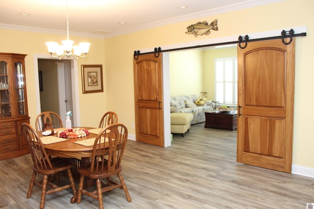 dining area featuring a barn door, light hardwood / wood-style flooring, and an inviting chandelier