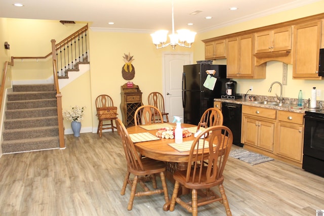 kitchen featuring decorative light fixtures, light stone counters, light hardwood / wood-style floors, a notable chandelier, and black appliances