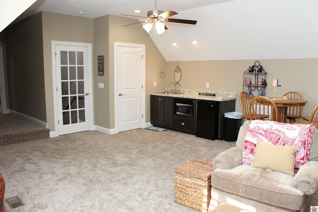 living room with ceiling fan, lofted ceiling, sink, and light carpet