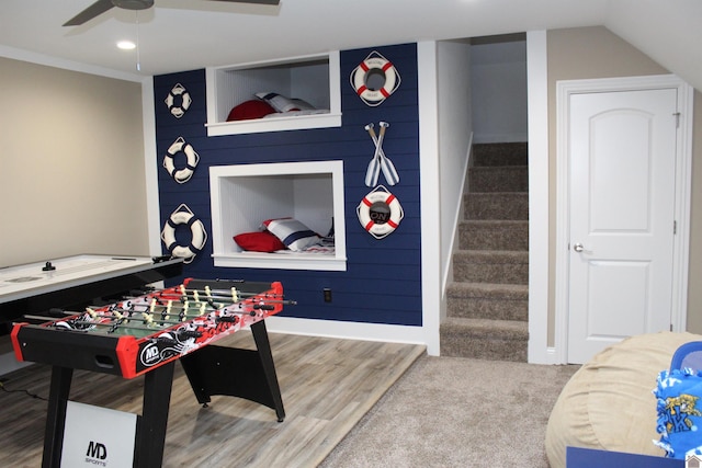 recreation room with ceiling fan, lofted ceiling, and light hardwood / wood-style flooring