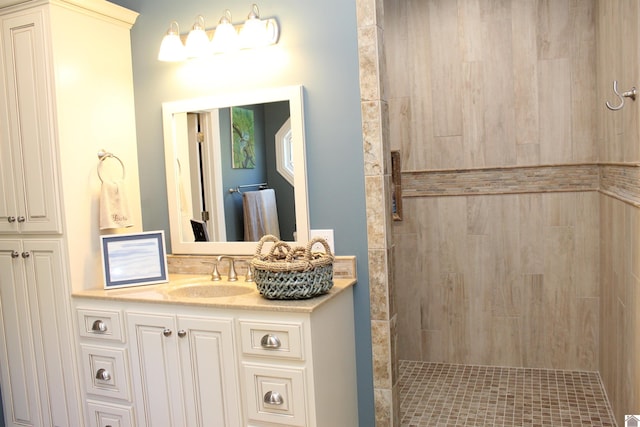 bathroom featuring a tile shower and vanity