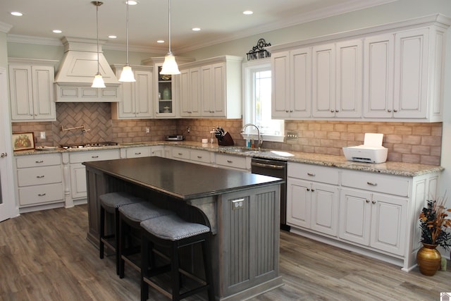 kitchen featuring premium range hood, a kitchen island, dark wood-type flooring, white cabinets, and backsplash