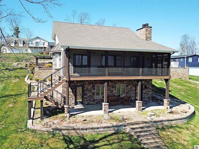 back of house with a sunroom, a lawn, and a patio area