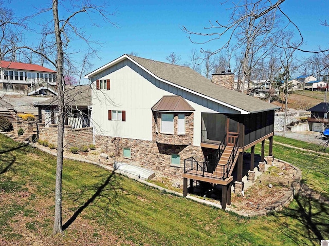 back of house featuring a yard and a sunroom