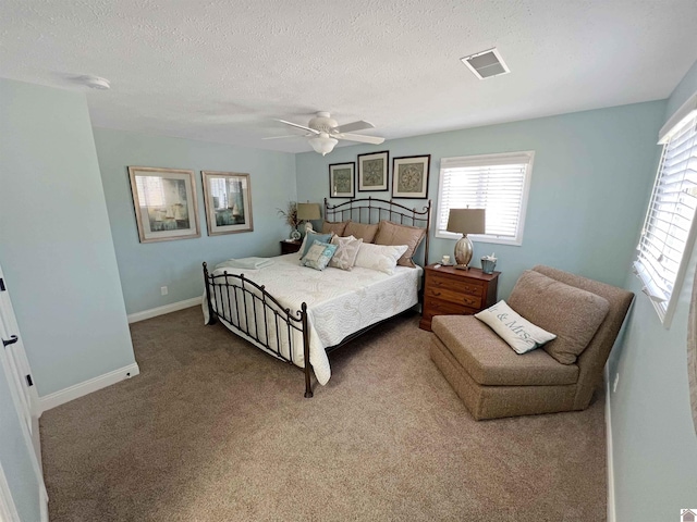 bedroom featuring ceiling fan, a textured ceiling, and dark carpet