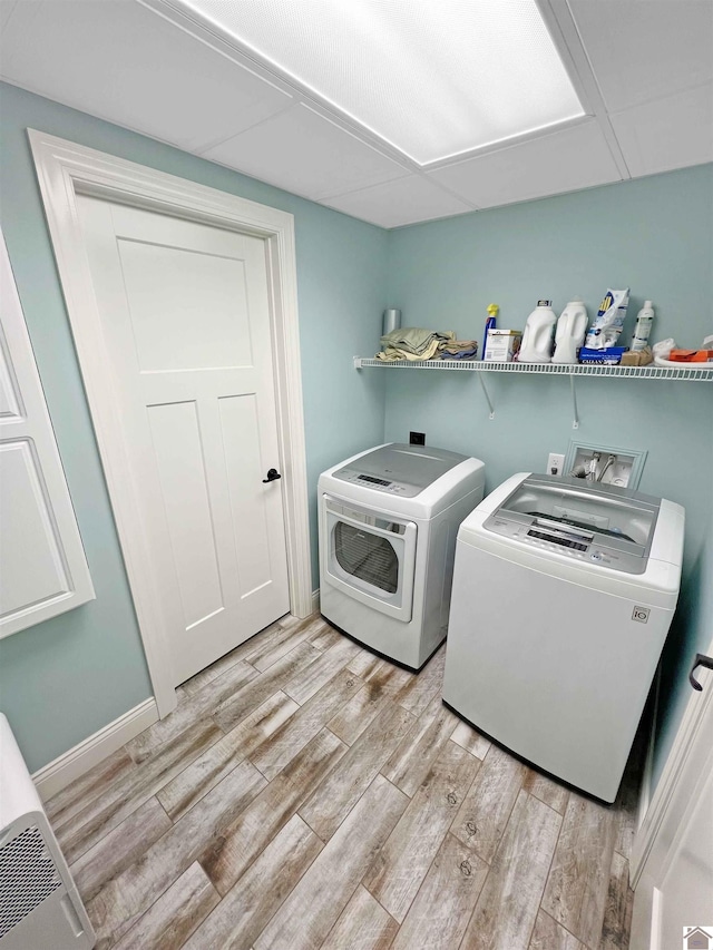 washroom with independent washer and dryer, light hardwood / wood-style flooring, and washer hookup