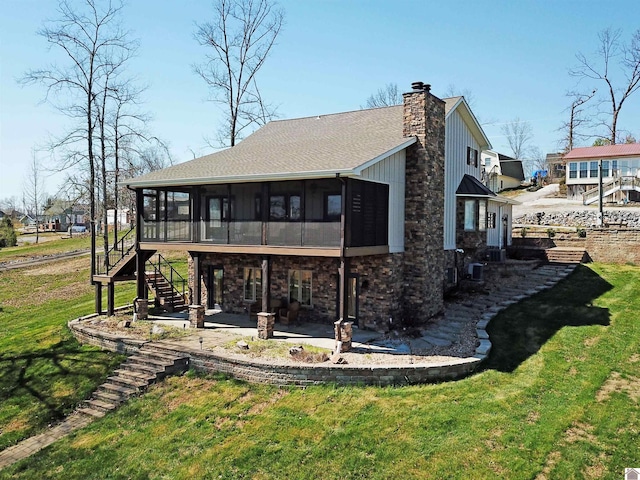 back of house with a yard, a patio area, and a sunroom