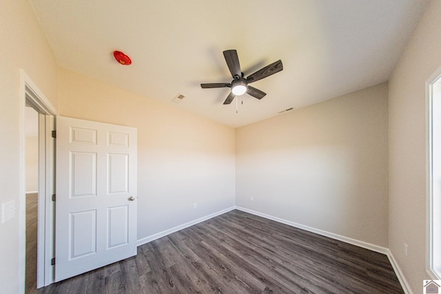 unfurnished room with dark hardwood / wood-style floors and ceiling fan