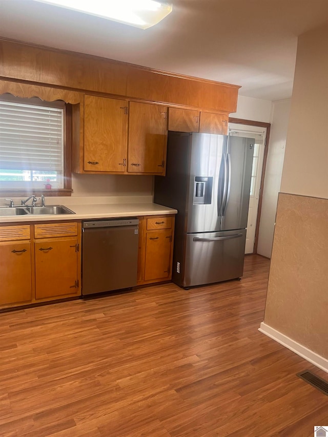 kitchen featuring appliances with stainless steel finishes, light hardwood / wood-style flooring, and sink