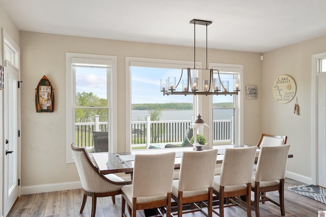 dining space with light hardwood / wood-style floors and a chandelier