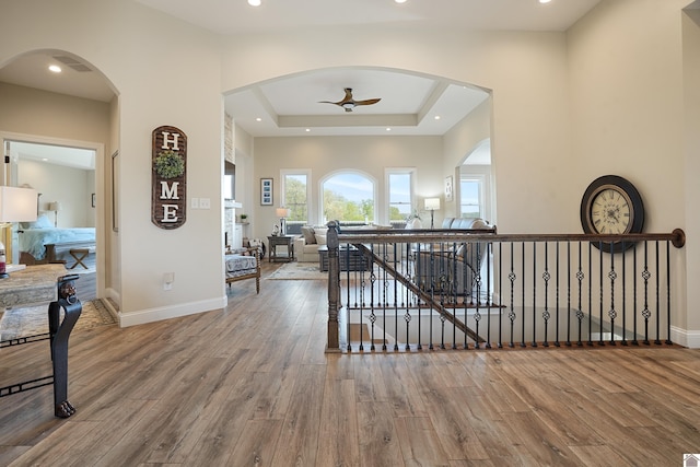 hallway with a raised ceiling and hardwood / wood-style flooring