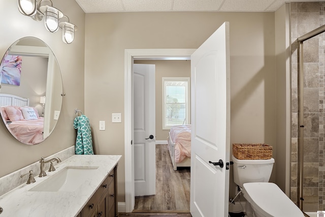 bathroom featuring a drop ceiling, wood-type flooring, toilet, and large vanity