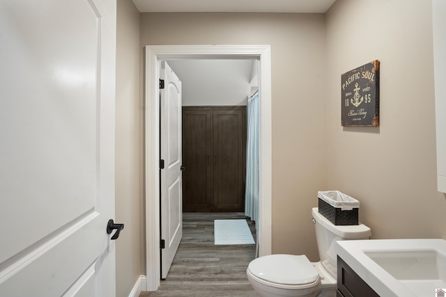 bathroom with hardwood / wood-style flooring, toilet, and vanity