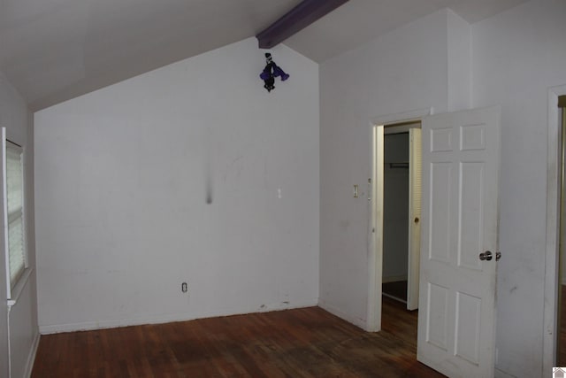 unfurnished bedroom with a walk in closet, dark hardwood / wood-style floors, a closet, and vaulted ceiling with beams