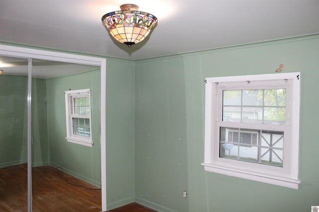 unfurnished bedroom with dark wood-type flooring and a closet