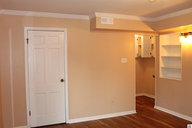 spare room featuring dark hardwood / wood-style flooring and crown molding