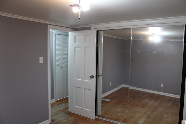 unfurnished bedroom featuring crown molding and hardwood / wood-style floors