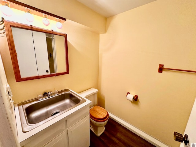 bathroom with hardwood / wood-style floors, vanity, and toilet