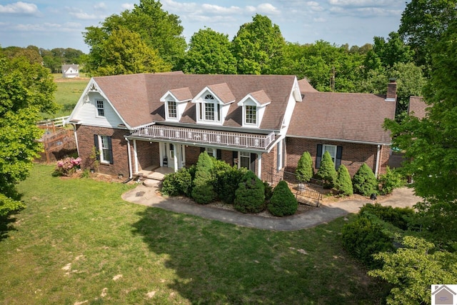 new england style home with covered porch and a front lawn