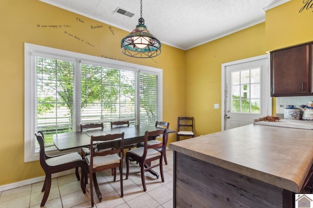 tiled dining room featuring a textured ceiling