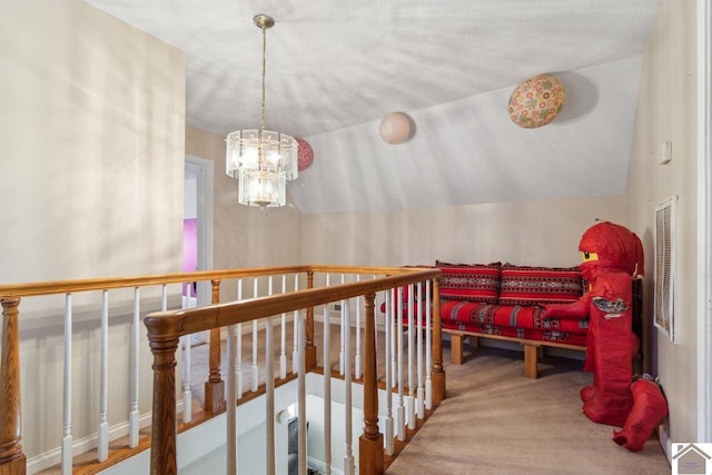 hall featuring a chandelier, carpet flooring, and vaulted ceiling