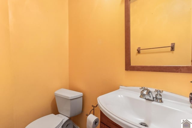 bathroom featuring vanity with extensive cabinet space and toilet