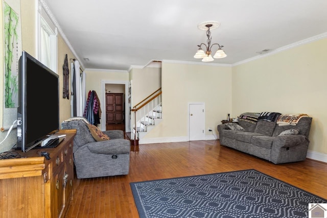 living room featuring an inviting chandelier, crown molding, and hardwood / wood-style floors