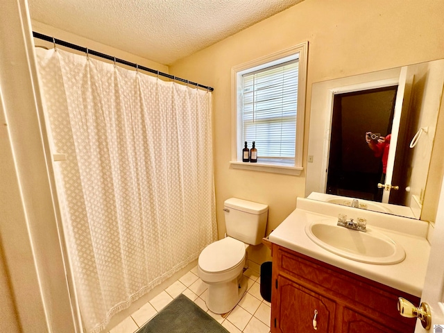 bathroom featuring toilet, tile floors, vanity, and a textured ceiling