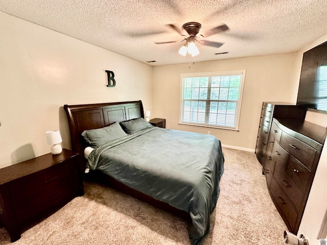 bedroom with light colored carpet, a textured ceiling, and ceiling fan