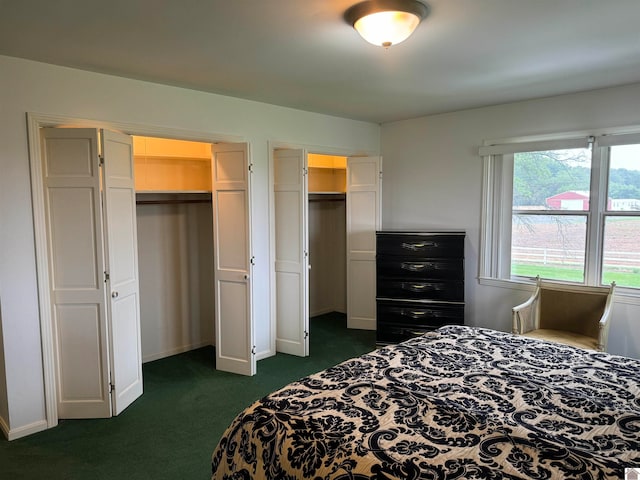 bedroom featuring dark carpet and multiple closets