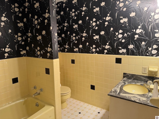 bathroom featuring tile walls, vanity, toilet, and tile flooring