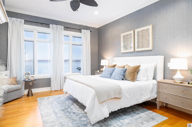 bedroom with a water view, ceiling fan, light hardwood / wood-style flooring, and crown molding