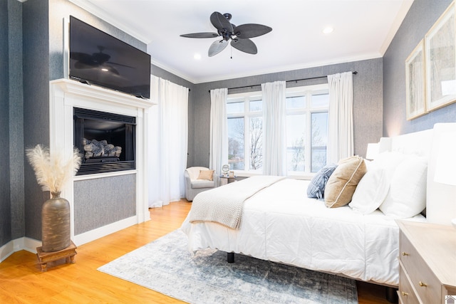 bedroom with ornamental molding, ceiling fan, and light wood-type flooring