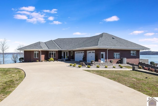 view of front of property featuring a garage, a water view, and a front yard